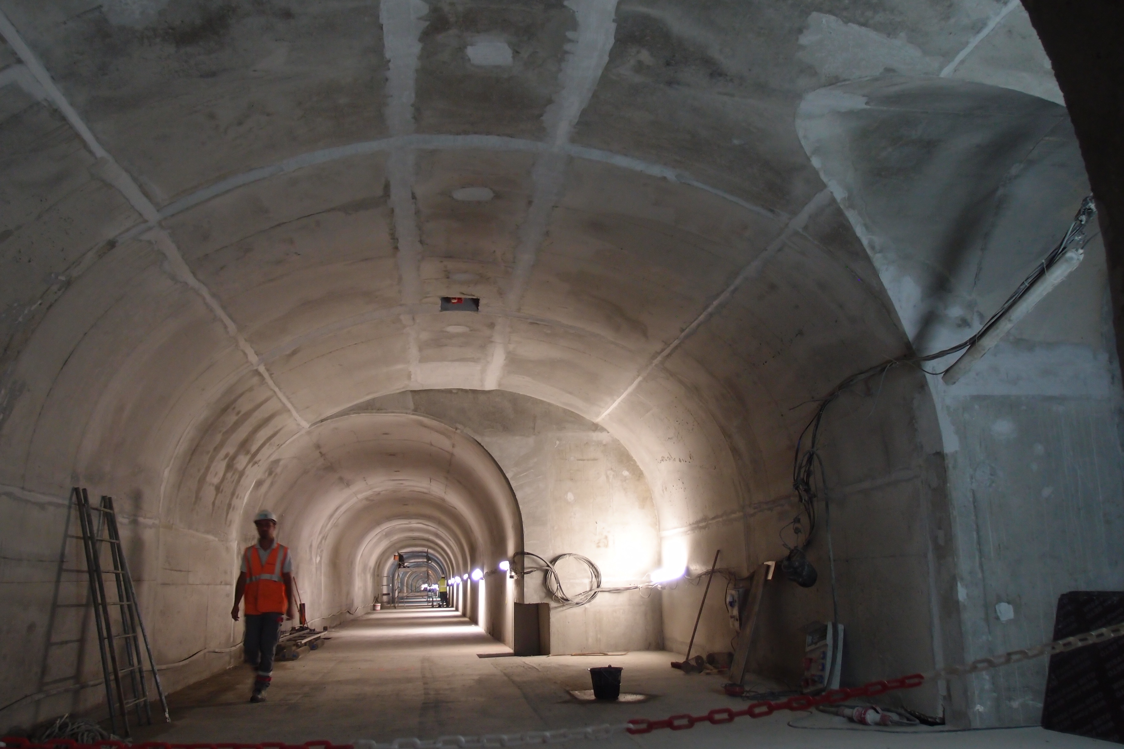 Travaux de finition du génie civil de la galerie du tunnel du Siaix – vue d'une surlargeur au droit d'un rameau de communication avec le tube routier (à droite)